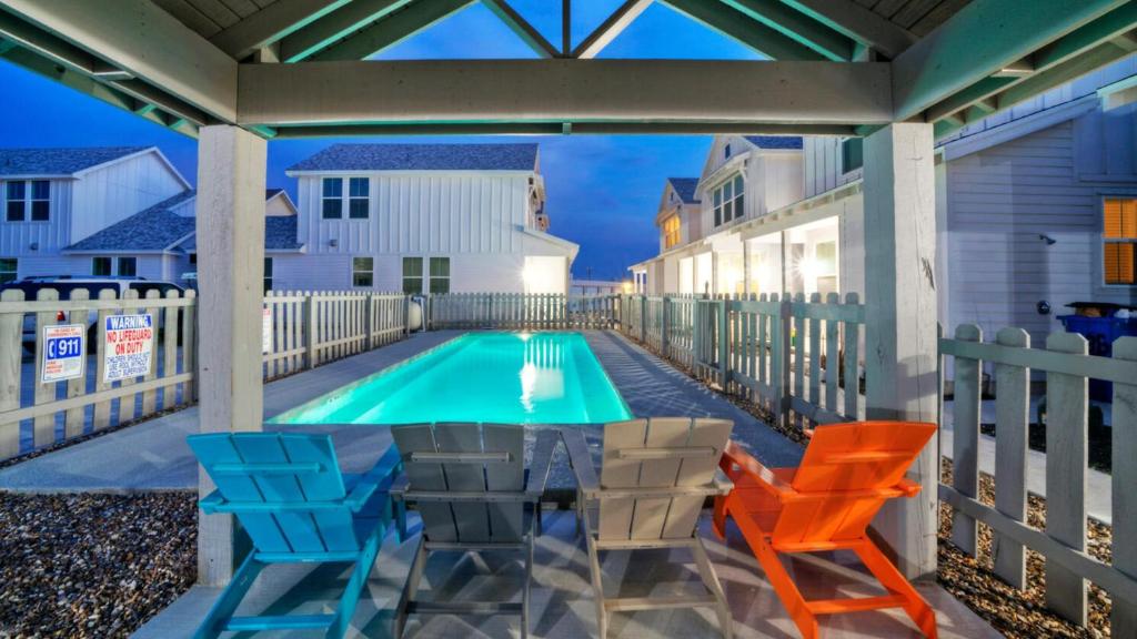 un patio con tavolo e sedie e una piscina di Newly Built Pool Walk to Old Town EatsMarina Shorely Goodness by AvantStay a Port Aransas