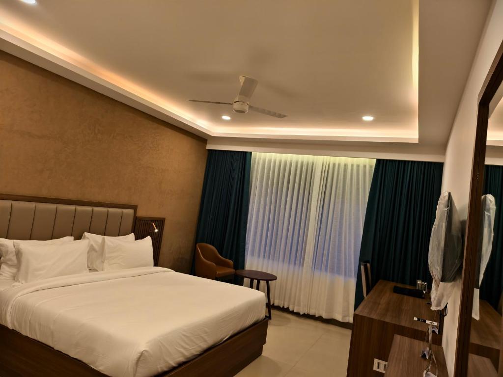 a hotel room with a bed and a window at Parays Fernwoods in Mannārakkāt