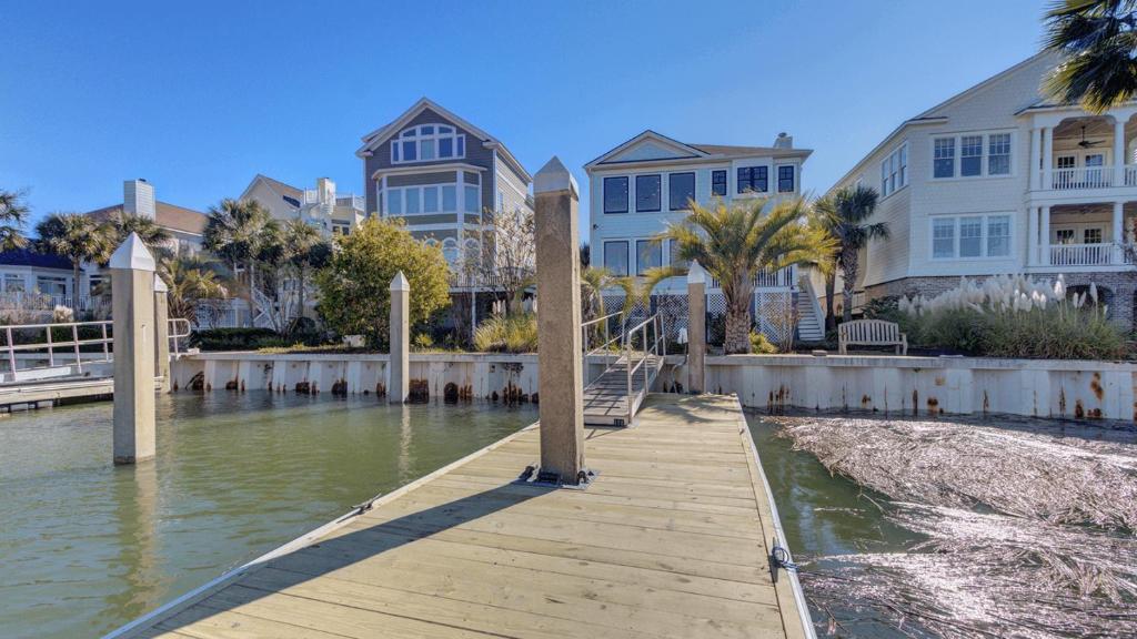a wooden dock in front of some buildings at 20 Morgan Place Drive by AvantStay Waterfront Home w Private Dock in Isle of Palms