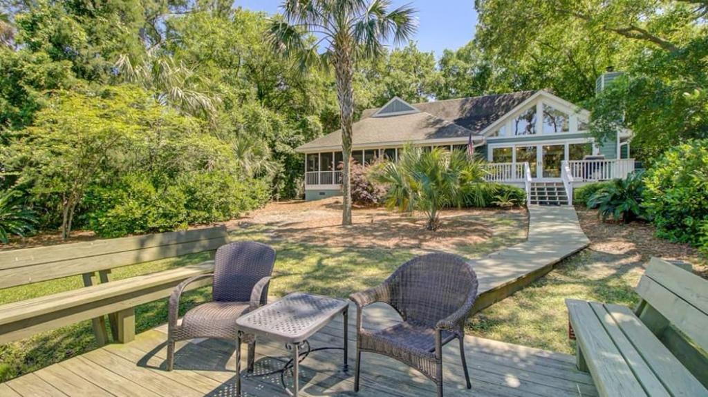 una casa con 2 sillas y una mesa en una terraza en 19 Oyster Row by AvantStay Lakefront Home w Golf Course Views, en Isle of Palms
