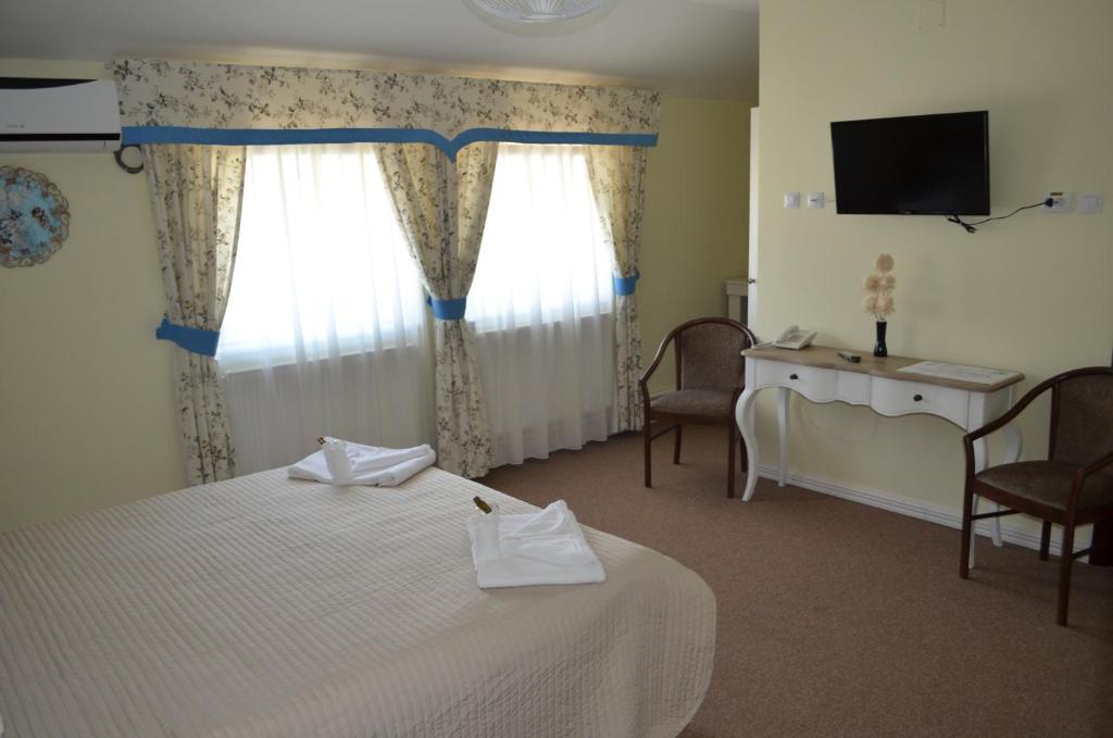 哈採格的住宿－Vip Motel Restaurant，一间卧室配有一张床、一张书桌和一台电视