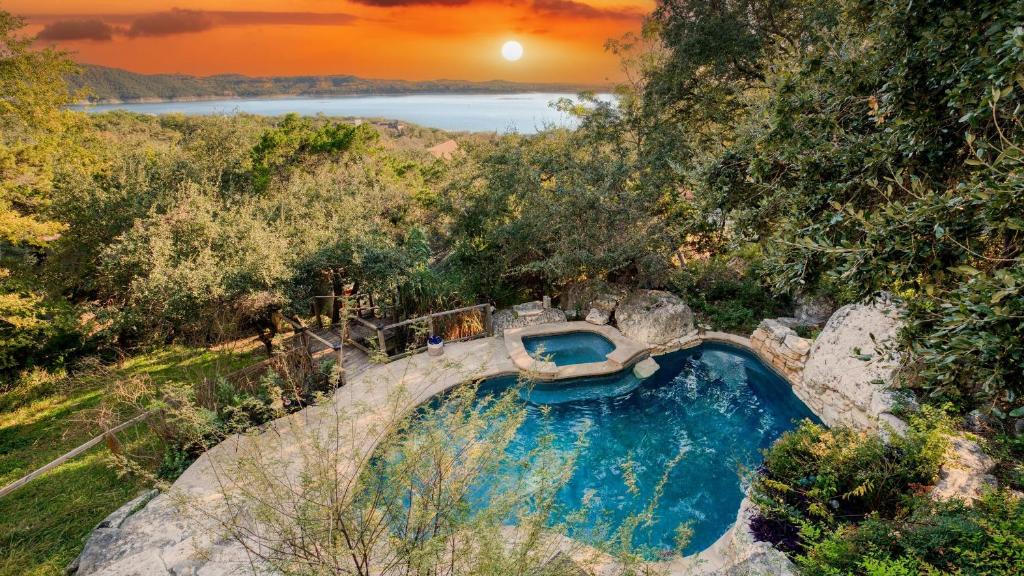 an overhead view of a pool in a hill with a sunset at Dawson by AvantStay Serene Austin Home set Amongst nature w Pool Close to Lake Travis in Austin