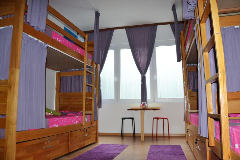 Pokój z 3 łóżkami piętrowymi i stołem w obiekcie Skopje Hostel w mieście Skopje