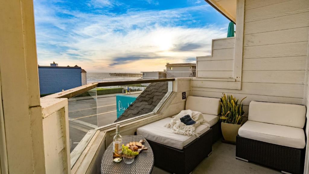 a balcony with a bed and a table and chairs at 2 Cayucan Bungalows Steps to Beach Shared Lounge Sleeps 12 in Cayucos