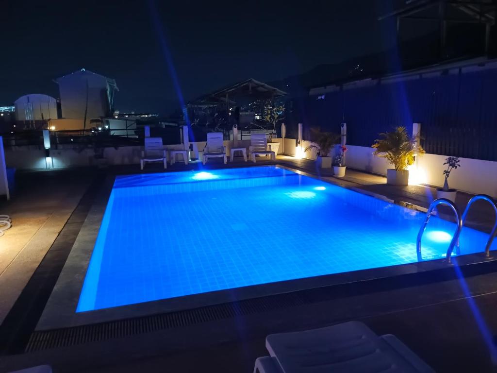 a swimming pool at night with lights on a building at EX-IT Inn in Patong Beach