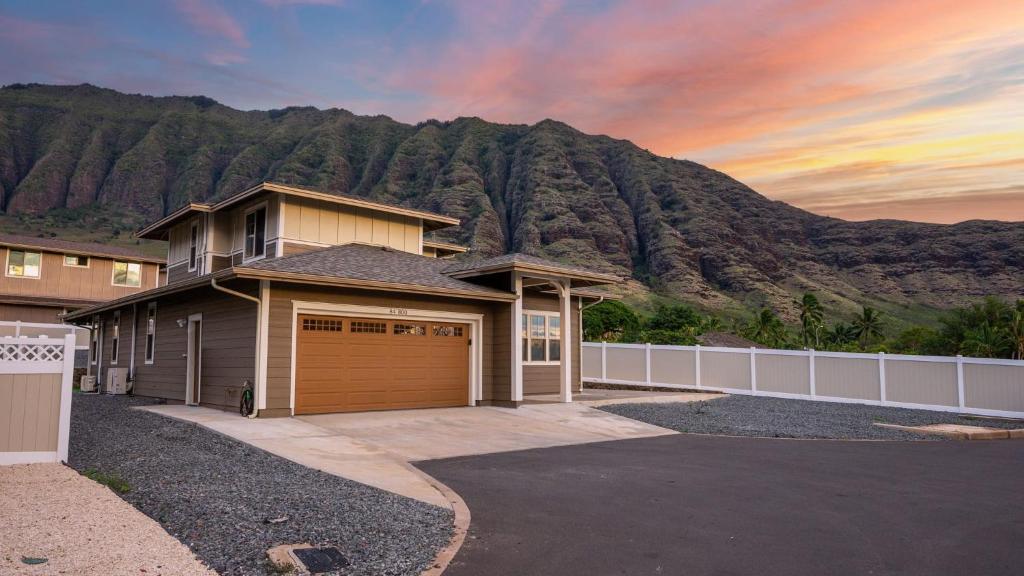 a house with a mountain in the background at Makaha Villa by AvantStay Mountain Ocean Views in Waianae