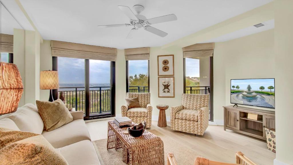 a living room with a couch and a tv at 303A Shipwatch by AvantStay Ocean View Shared Pool Boardwalk to Beach in Isle of Palms