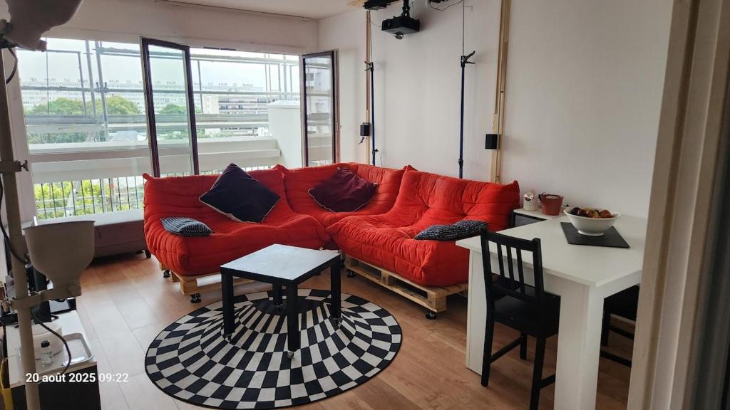 CourcouronnesにあるChambre 1 Personneの赤いソファとテーブルのあるリビングルーム