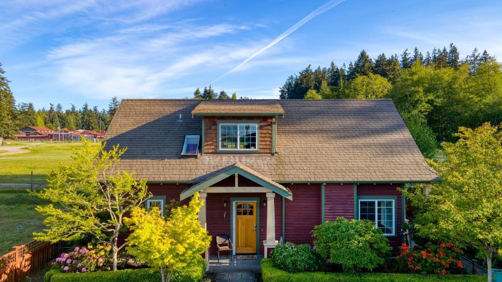 a red house with a brown roof at Sunny Backyard Fireplace Coastal Access in Peaceful Neighborhood Near Shopping in Langley