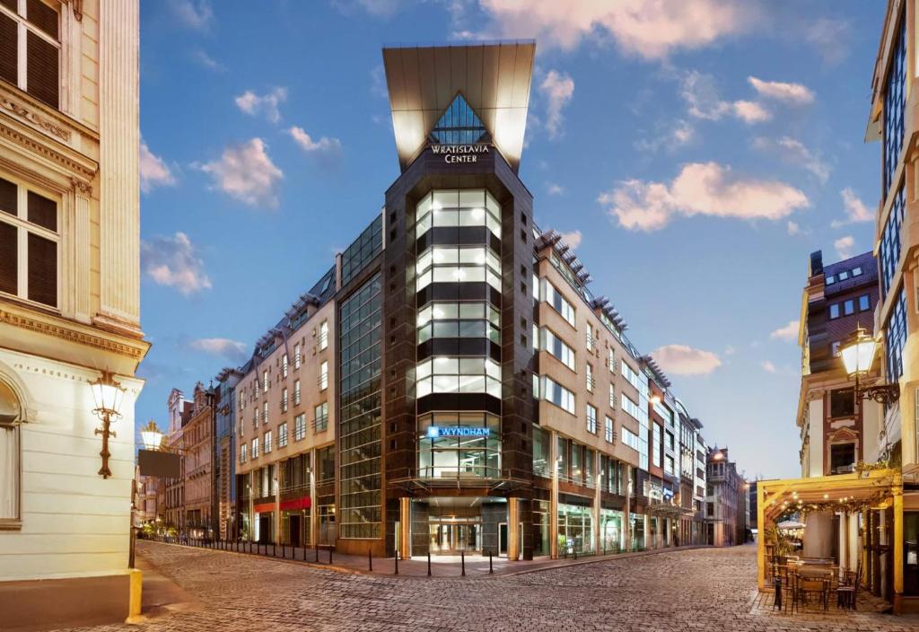 a building with a tower on top of a street at Wyndham Wroclaw Old Town in Wrocław