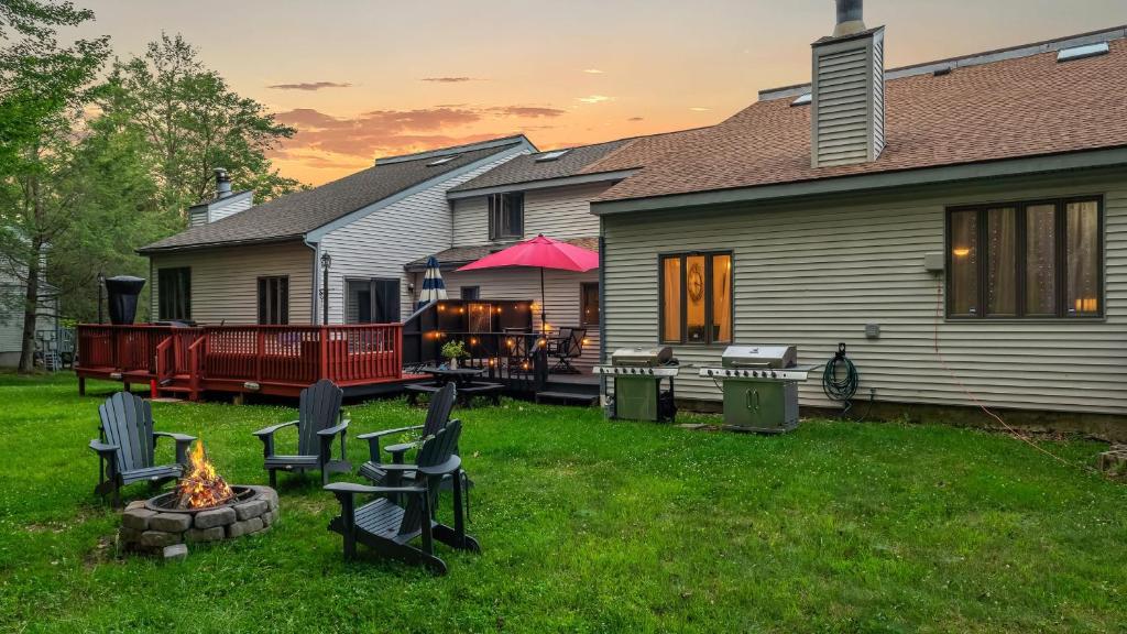 a backyard with chairs and a fire pit and a house at Lakeside Haven Ping Pong Fire Pit Mins to Big Boulder Lake Harmony in Lake Harmony