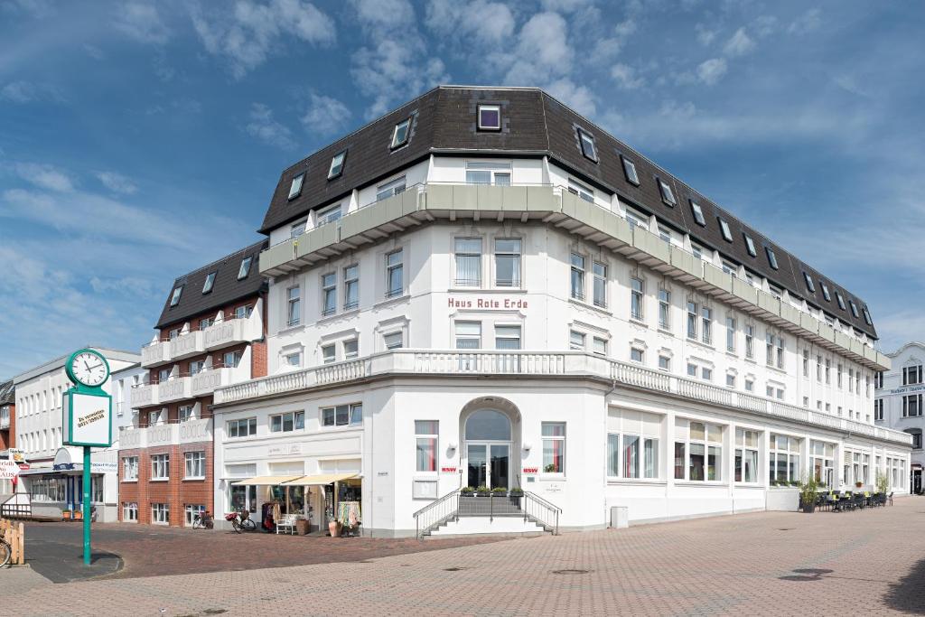 um grande edifício branco com um telhado preto em Inselhotel Rote Erde em Borkum