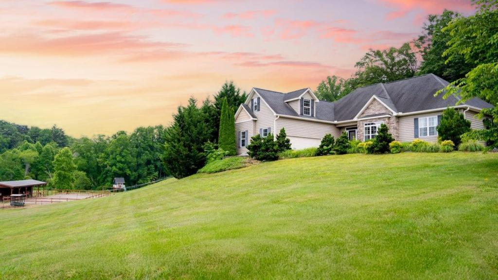 a house on a hill with a green lawn at Fairview Vista by AvantStay 10 Mins to Asheville in Fairview
