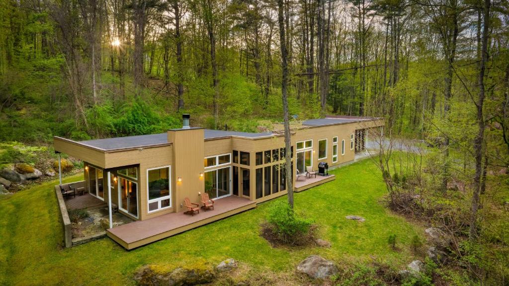 an aerial view of a house in the woods at Woodland Zen by AvantStay Modern Design Patio in Stockbridge