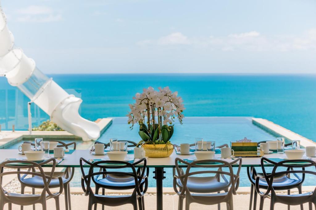 a table with chairs and a vase of flowers at Villa Turquoise in Bophut 