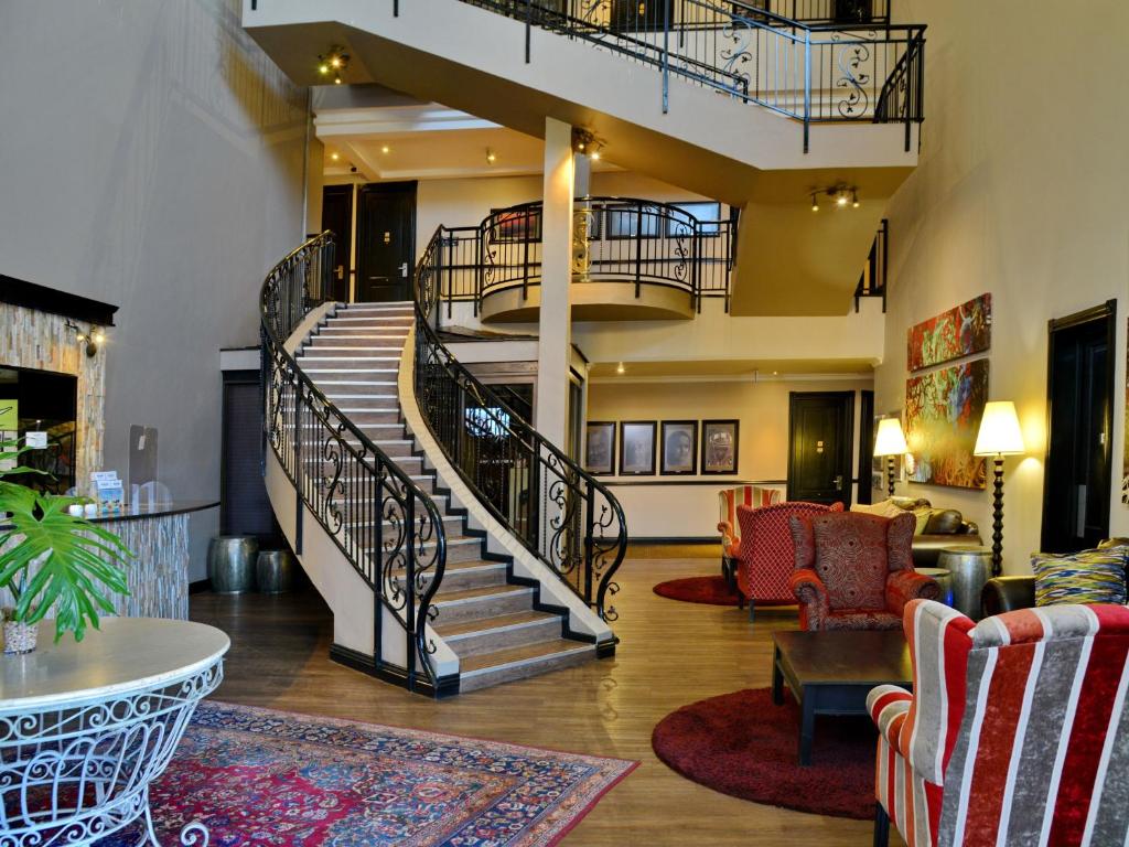 eine Lobby mit Wendeltreppe und ein Wohnzimmer in der Unterkunft ANEW Hotel Highveld Emalahleni in Witbank