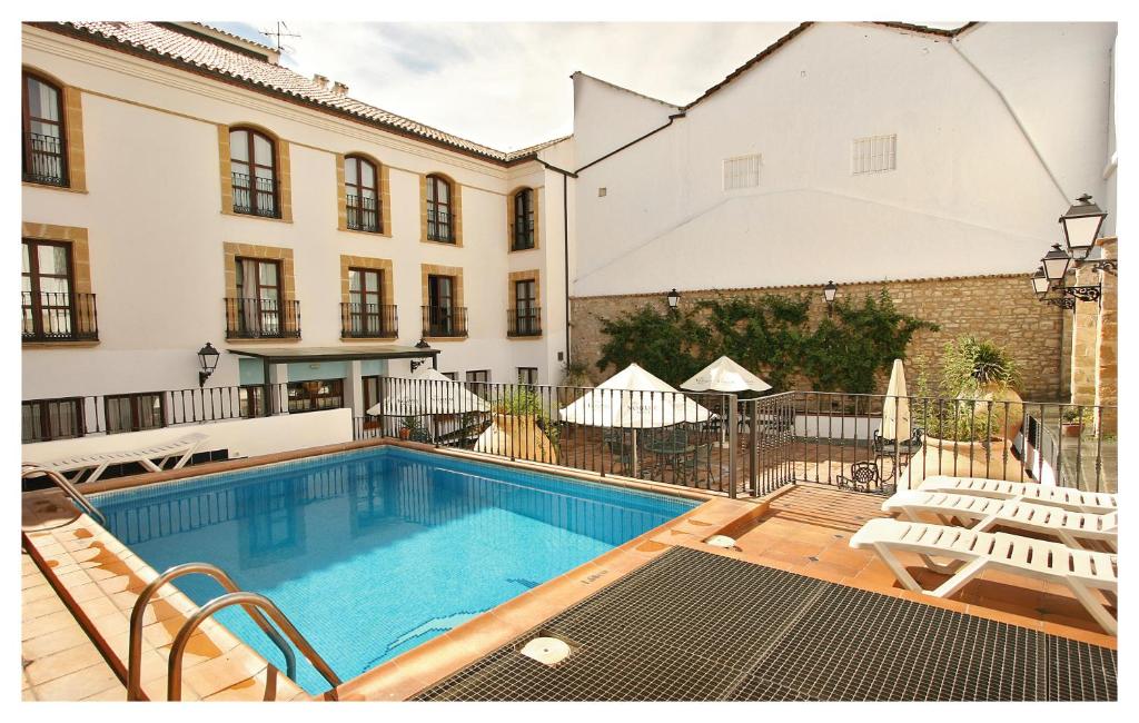 une piscine en face d'un bâtiment dans l'établissement Hotel Rosaleda Don Pedro, à Úbeda