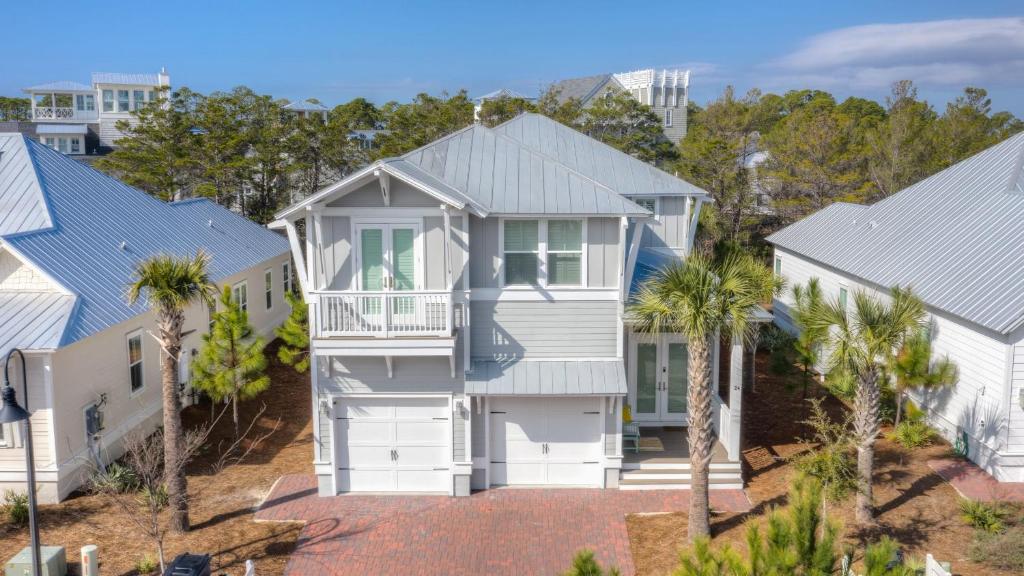 an aerial view of a white house with palm trees at Coconut Cove by AvantStay Deck w Hot Tub Access to 2 Pools in Santa Rosa Beach