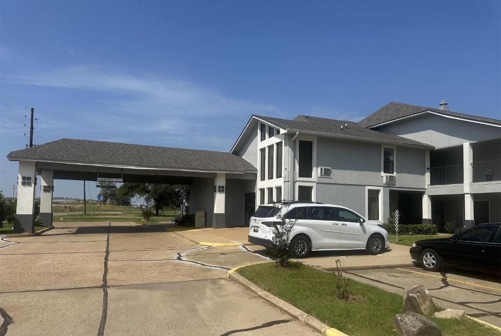 a white car parked in front of a house at Super 8 by Wyndham Bossier City/Shreveport Area in Bossier City