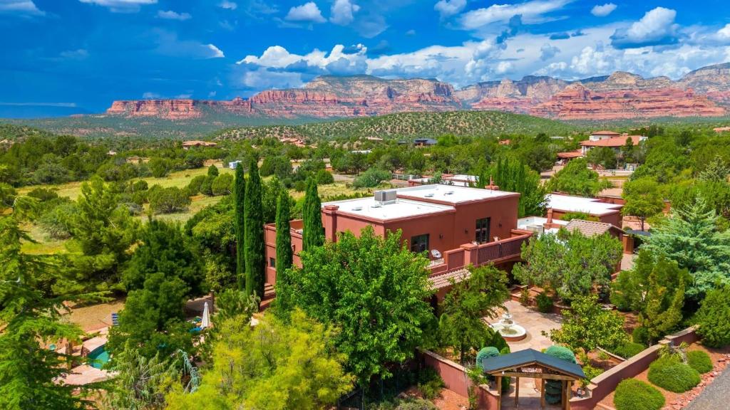 Una vista aérea de un edificio con montañas al fondo. en Mystic Sunset by AvantStay Thunder Mountain View Pool Driving Range Casita, en Sedona