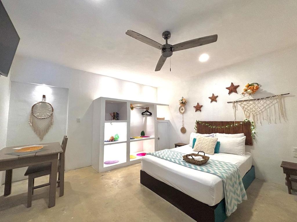 a bedroom with a bed and a ceiling fan at CasaMarena in Isla Mujeres