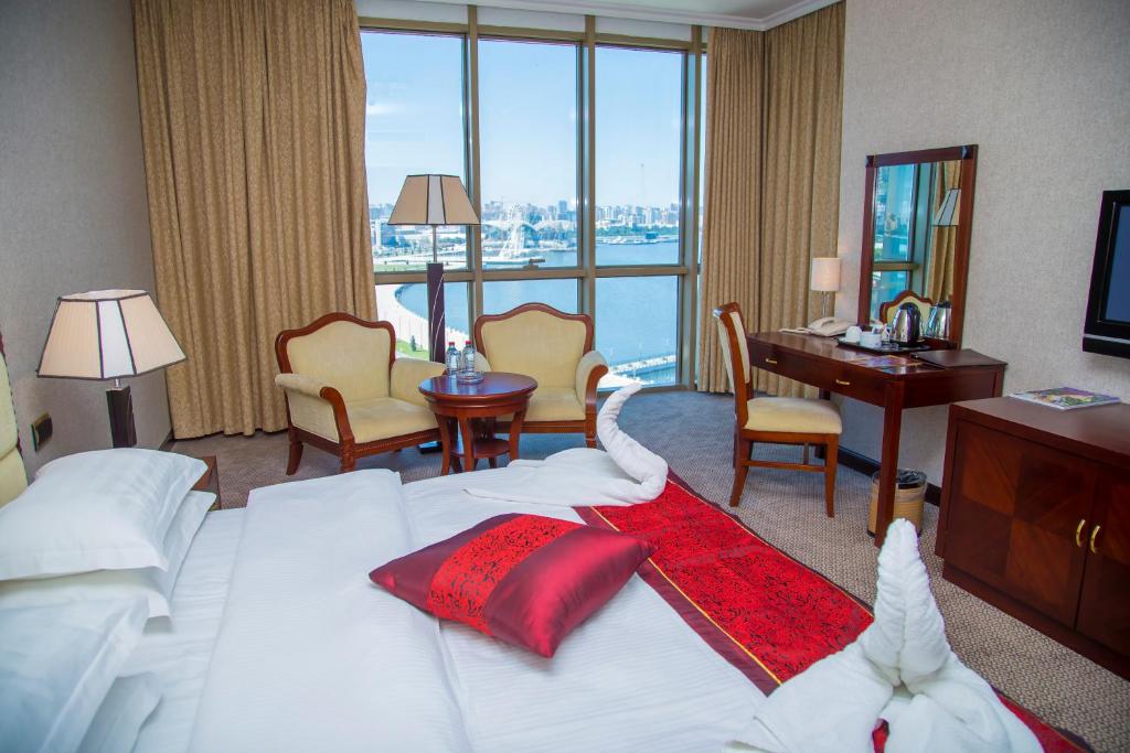 Golden Coast Hotel في باكو: غرفة في الفندق مع سرير كبير مع مكتب ومكتب