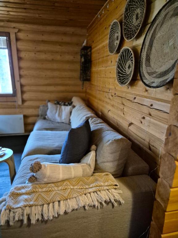 a person laying on a couch in a room at Log cabin Ylläs Valokki - sauna, fireplace, Ylläs view in Ylläsjärvi