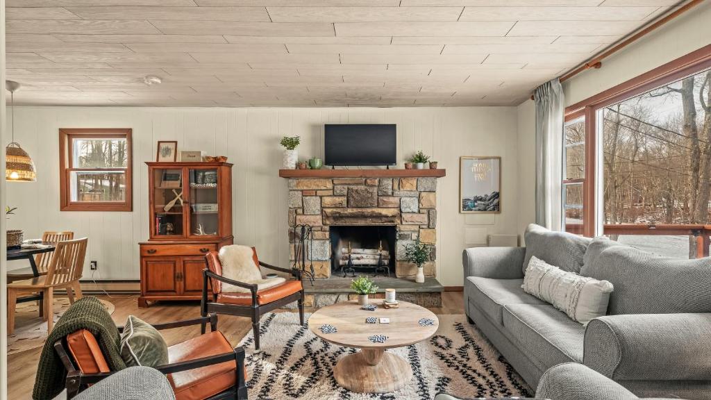 Pocono LakeThe Pines Cozy Arrowhead Lake Escape with Pools and Outdoor Adventures的带沙发和壁炉的客厅