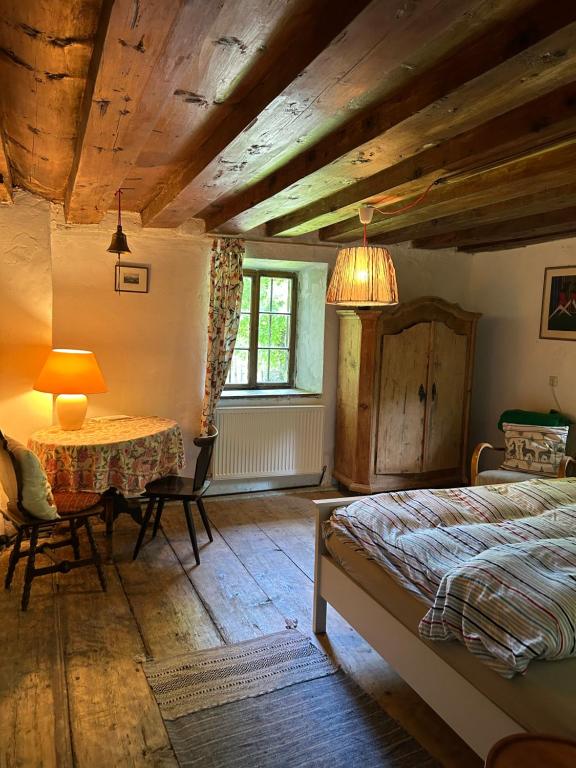 a bedroom with a bed and a table and a window at 1690 Heritage Farmhouse-barn in Kuchl