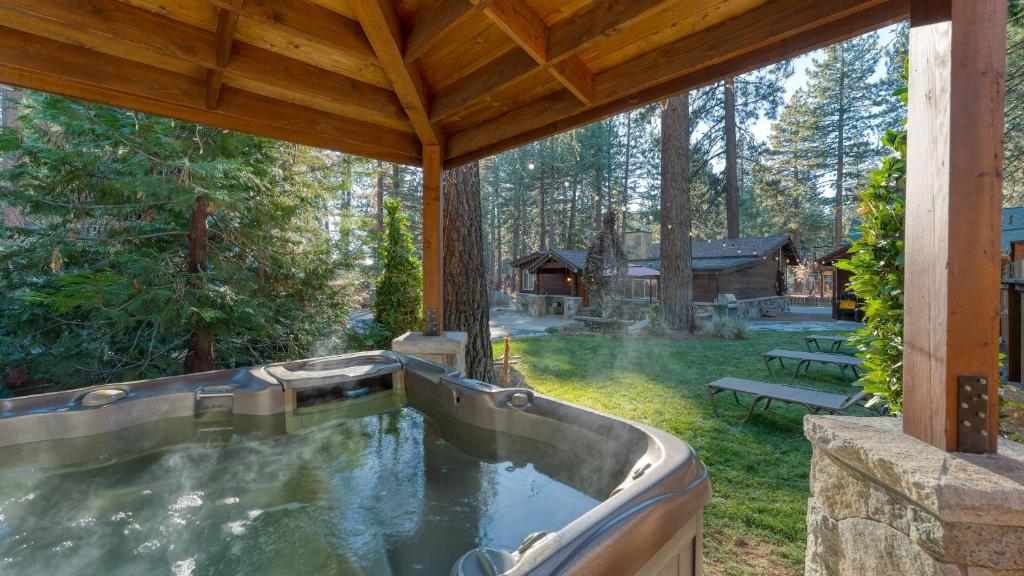 una vasca idromassaggio nel cortile di una baita di tronchi di Lake Star by AvantStay Hot Tub Walk to Beach a Kings Beach