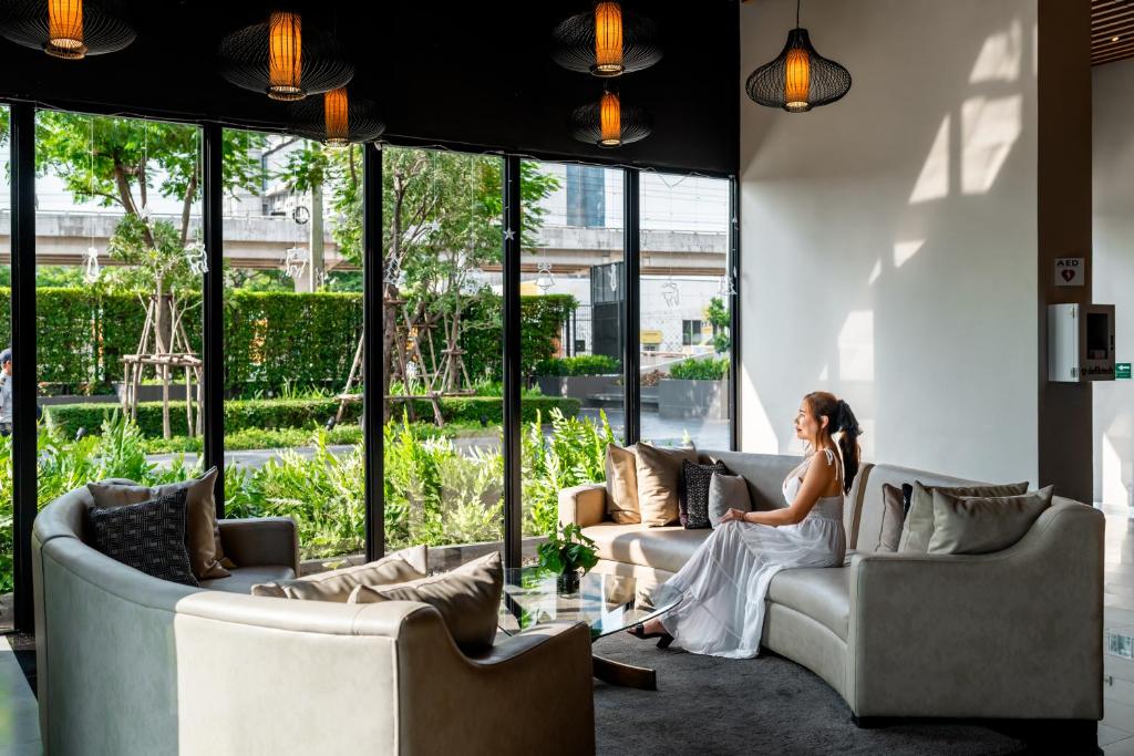 A sunlit lobby lounge with curved sofas overlooking landscaped grounds.