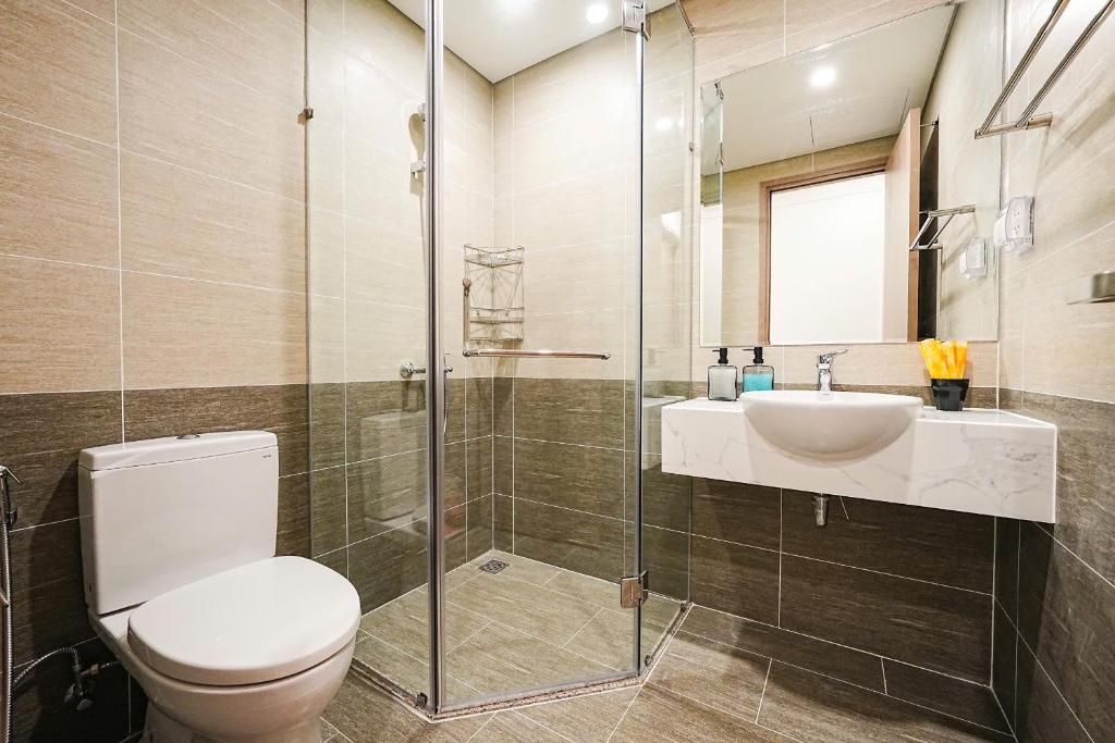ein Badezimmer mit Toilette, Waschbecken und Dusche in der Unterkunft The Place-Vinhome-Gold in Gò Công