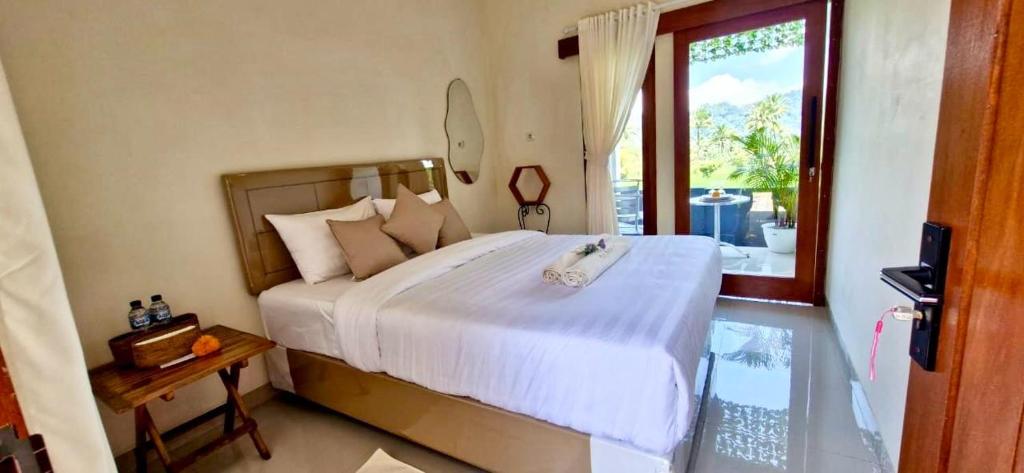 SelatにあるThe Sangka roomsの大きなベッドと大きな窓のある寝室