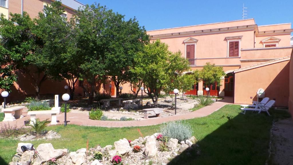 un jardin en face d'un bâtiment dans l'établissement Oasi Ottocento, à Quartu SantʼElena