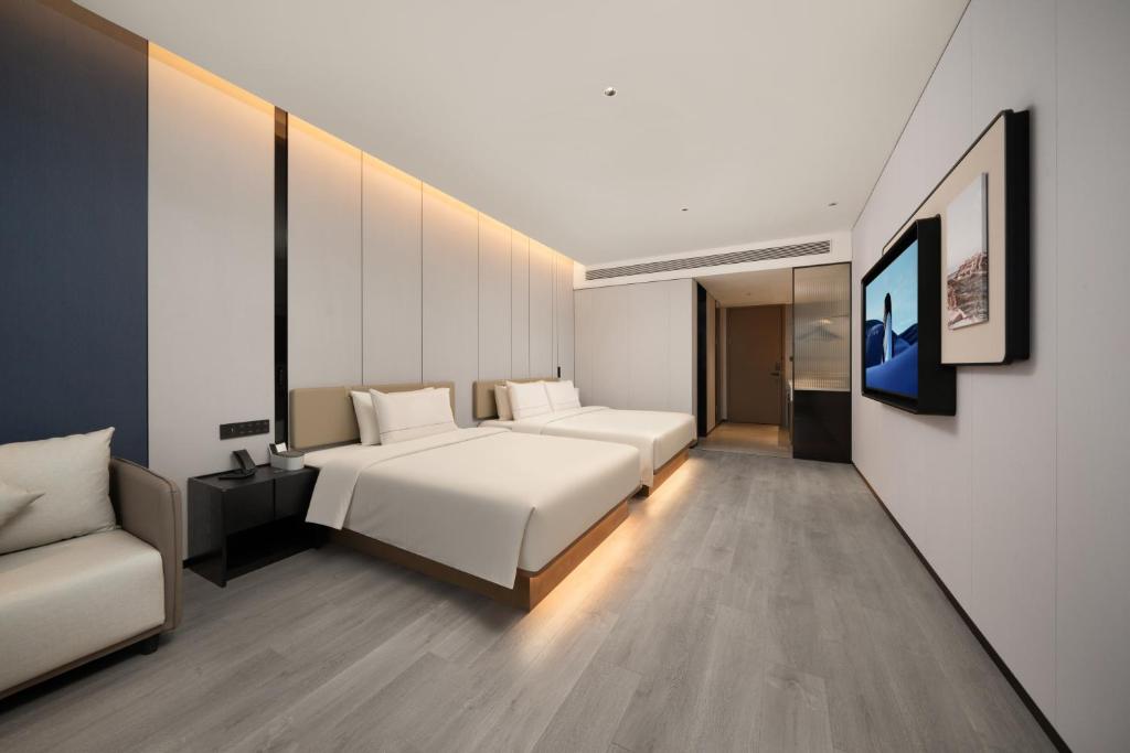 a hotel room with a bed and a couch at Atour Hotel Pengbo Central Plaza Lanzhou Zhongchuan Airport in Lanzhou