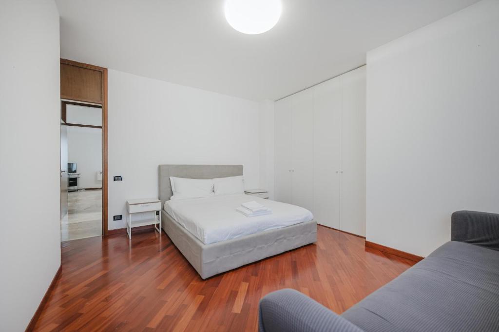 - une chambre blanche avec un lit et un canapé dans l'établissement Ca' Nina - 15 min from Venice & Free Parking, à Venise