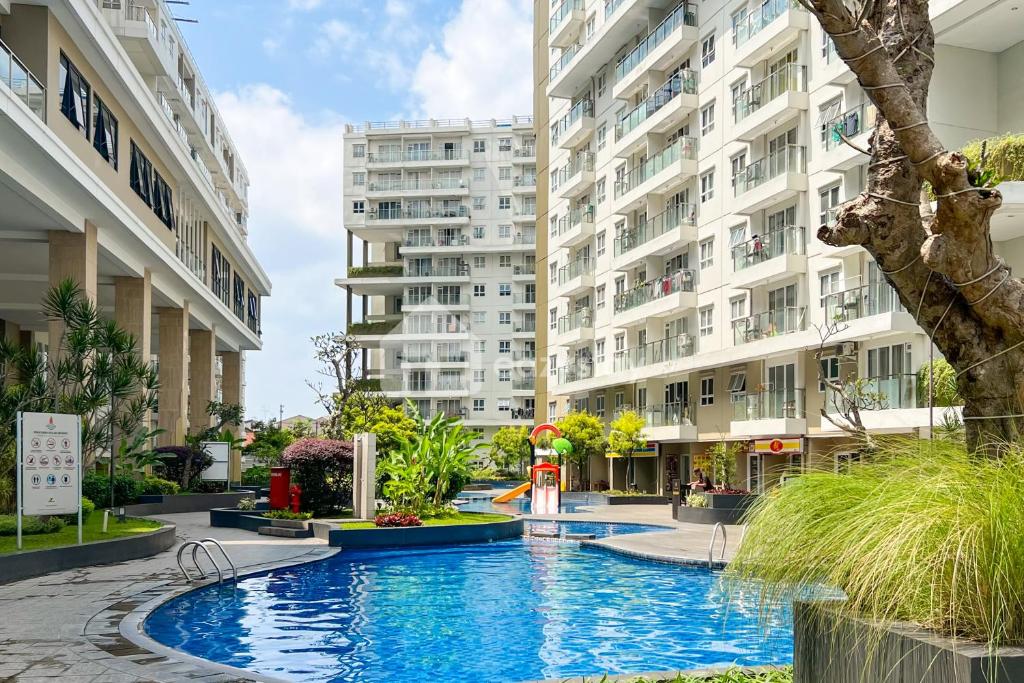 a swimming pool in front of two tall buildings at Eazystay Gateway Pasteur Apartment in Bandung