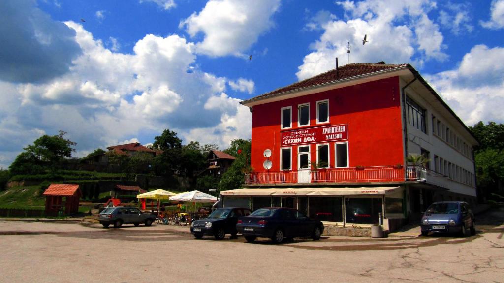 ein rotes Gebäude mit davor geparkt in der Unterkunft Suhin Dol Hotel in Belimel