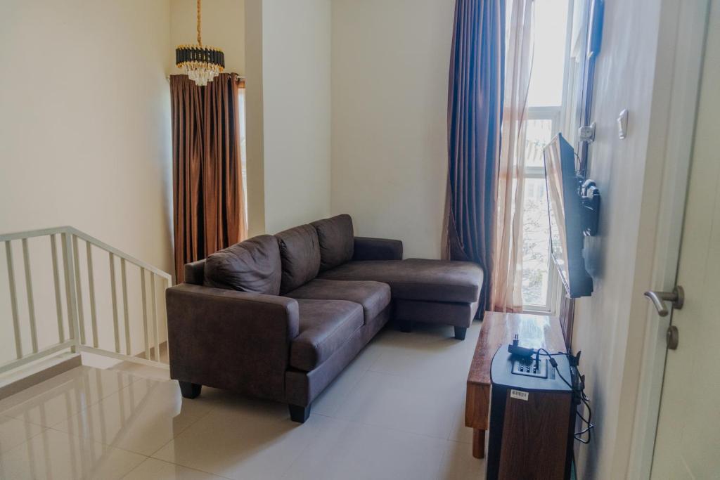 a living room with a brown couch and a window at Villa Exotic 22 Batu in Tlekung