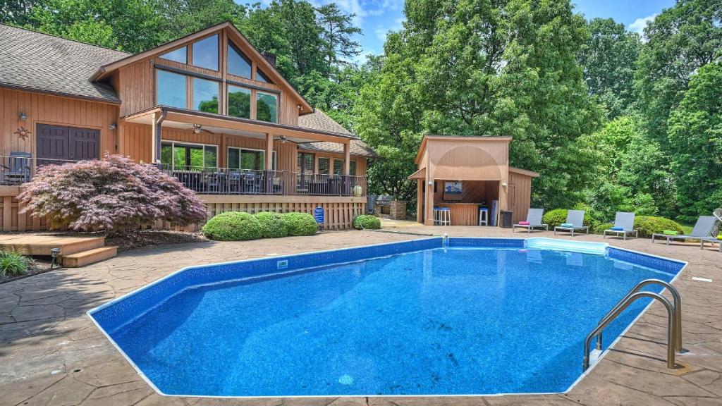 a house with a swimming pool in front of a house at Stay Awhile by AvantStay Lakefront Pool Dock in Mooresville