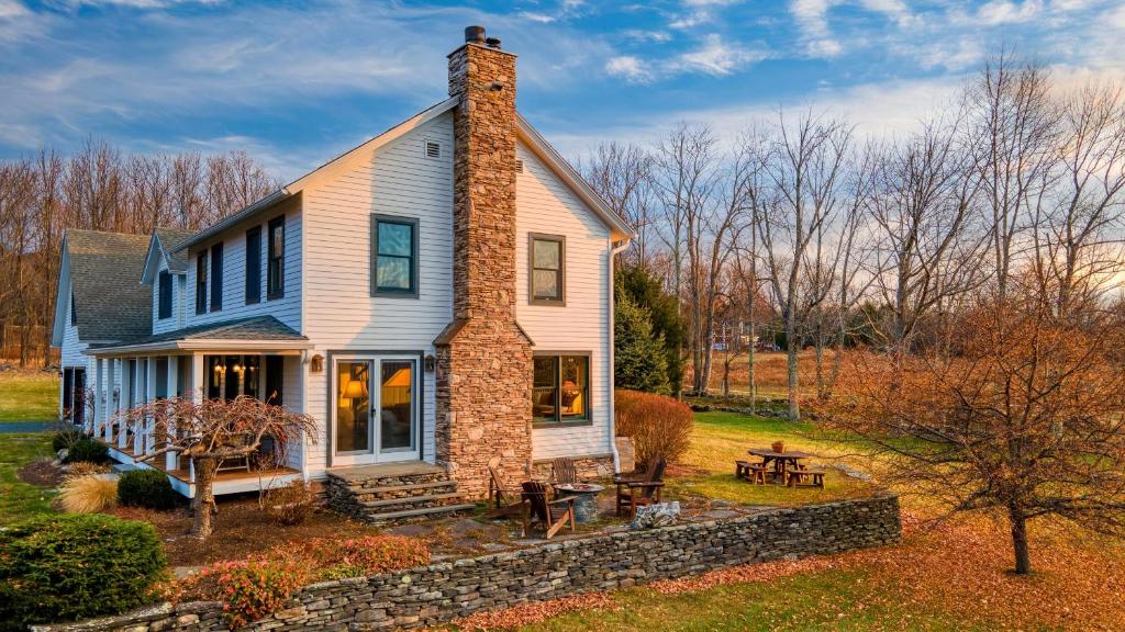a white house with a brick chimney on top at Catskill Park Farm by AvantStay Huge Yard Fire Pit Near Windham Ski Resort in Prattsville