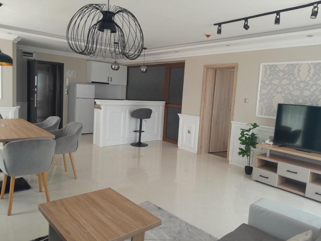 a living room with a television and a dining room at Vemara City Boutique Hotel-free parking in Varna City