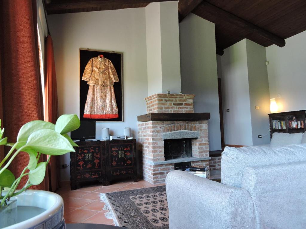 una sala de estar con chimenea y un vestido colgado en la pared en Cascina Volpona, en Case Bruciate