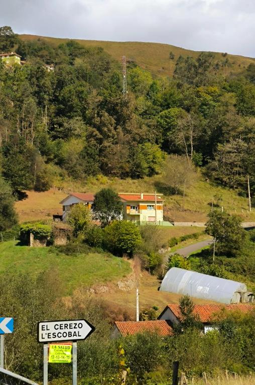 a house on the side of a hill with a street sign at Casa las granxias in El Escobal