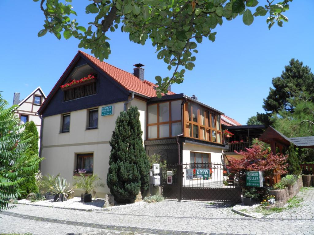 a large house with a tree in front of it at Pension Sonja Müller in Nohra