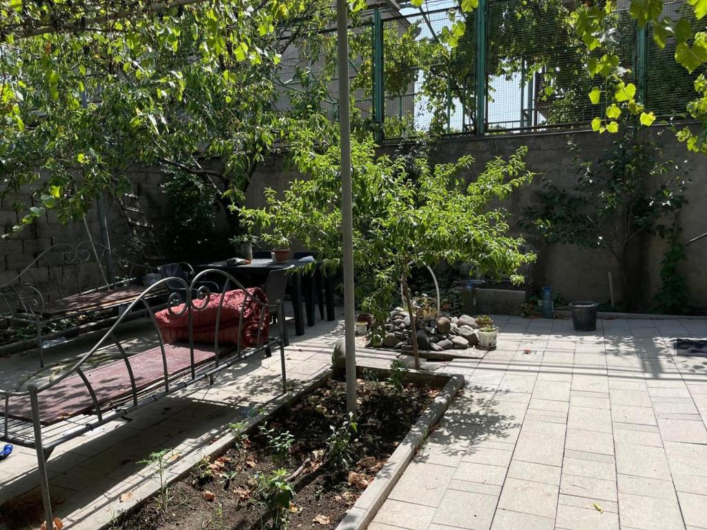 ルスタヴィにあるHappy Rustavi guest houseのベンチとテーブルと木々のある庭園