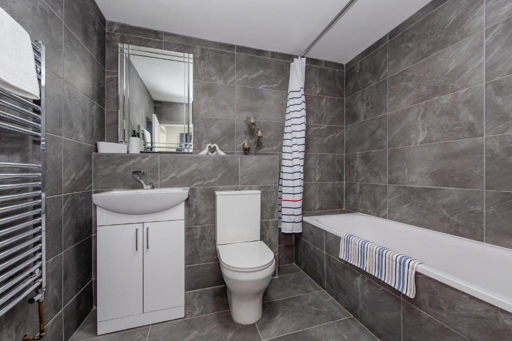 a bathroom with a toilet and a sink and a tub at Triple B Aparto in Clacton-on-Sea