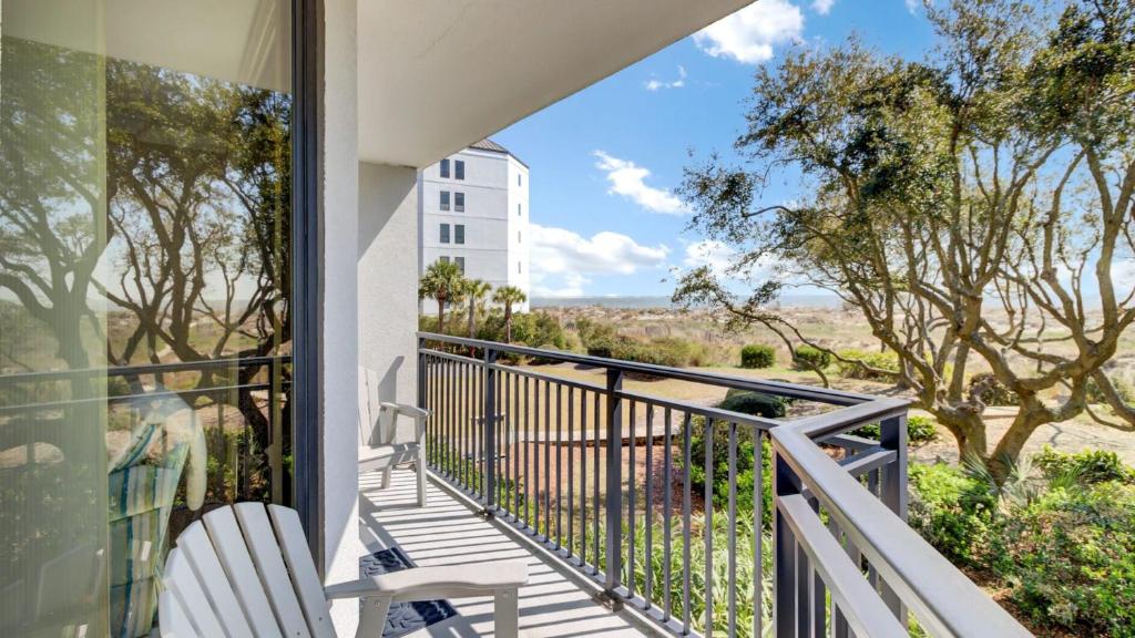 a balcony with chairs and a view of the desert at 123D Shipwatch by AvantStay Beach Access Pool in Isle of Palms