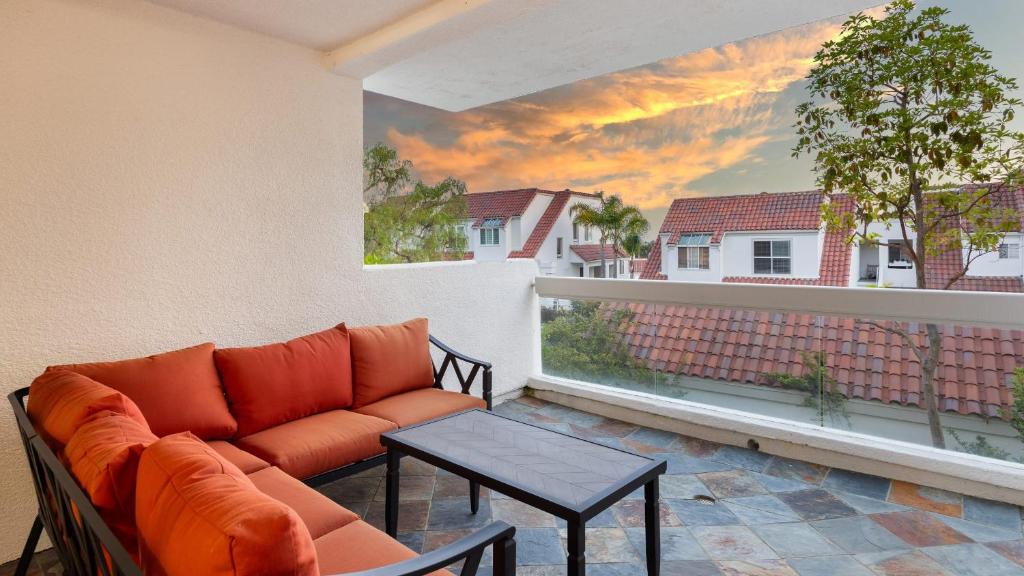 - un salon avec un canapé et une table sur un balcon dans l'établissement Encantamar Escape by AvantStay Prime Location Community Amenities, à Dana Point