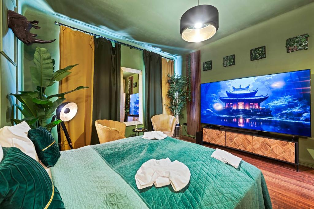 Hotel Jungle Apartment Vienna, a bedroom with a green bed and a large screen tv at Jungle Apartment Vienna in Vienna